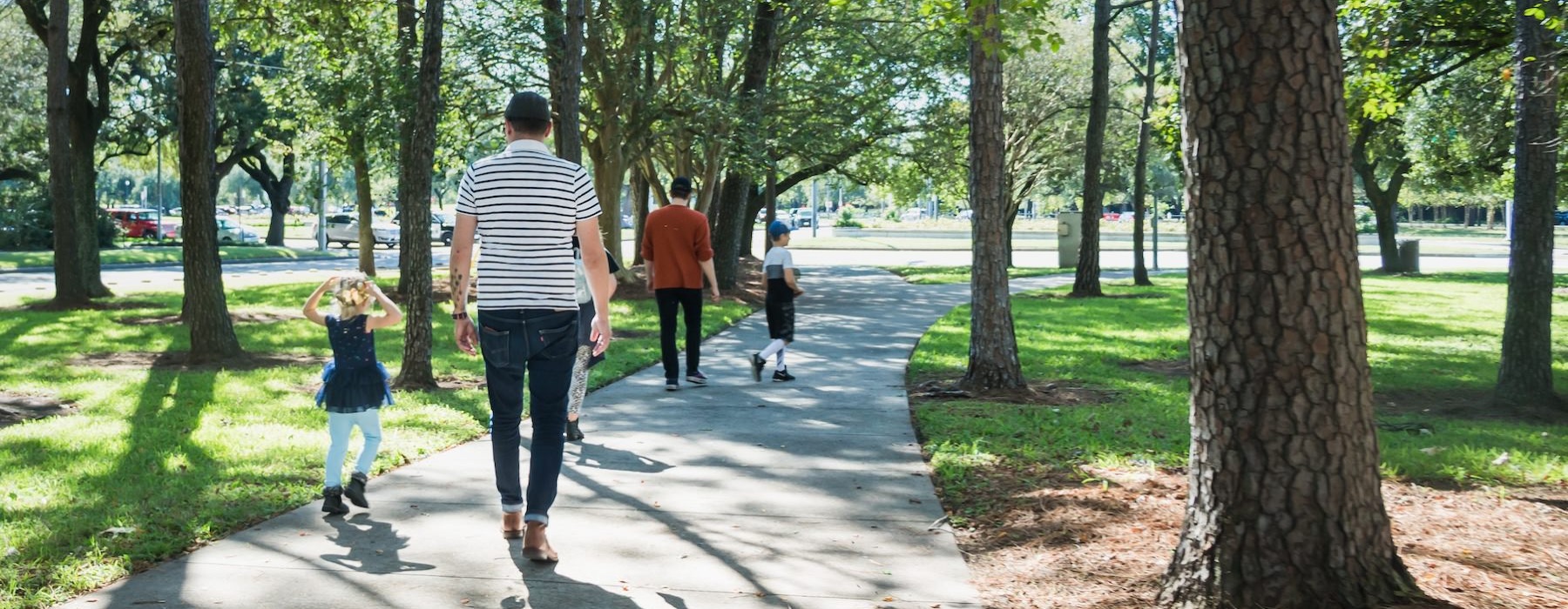 a group of people walking on a path in a park